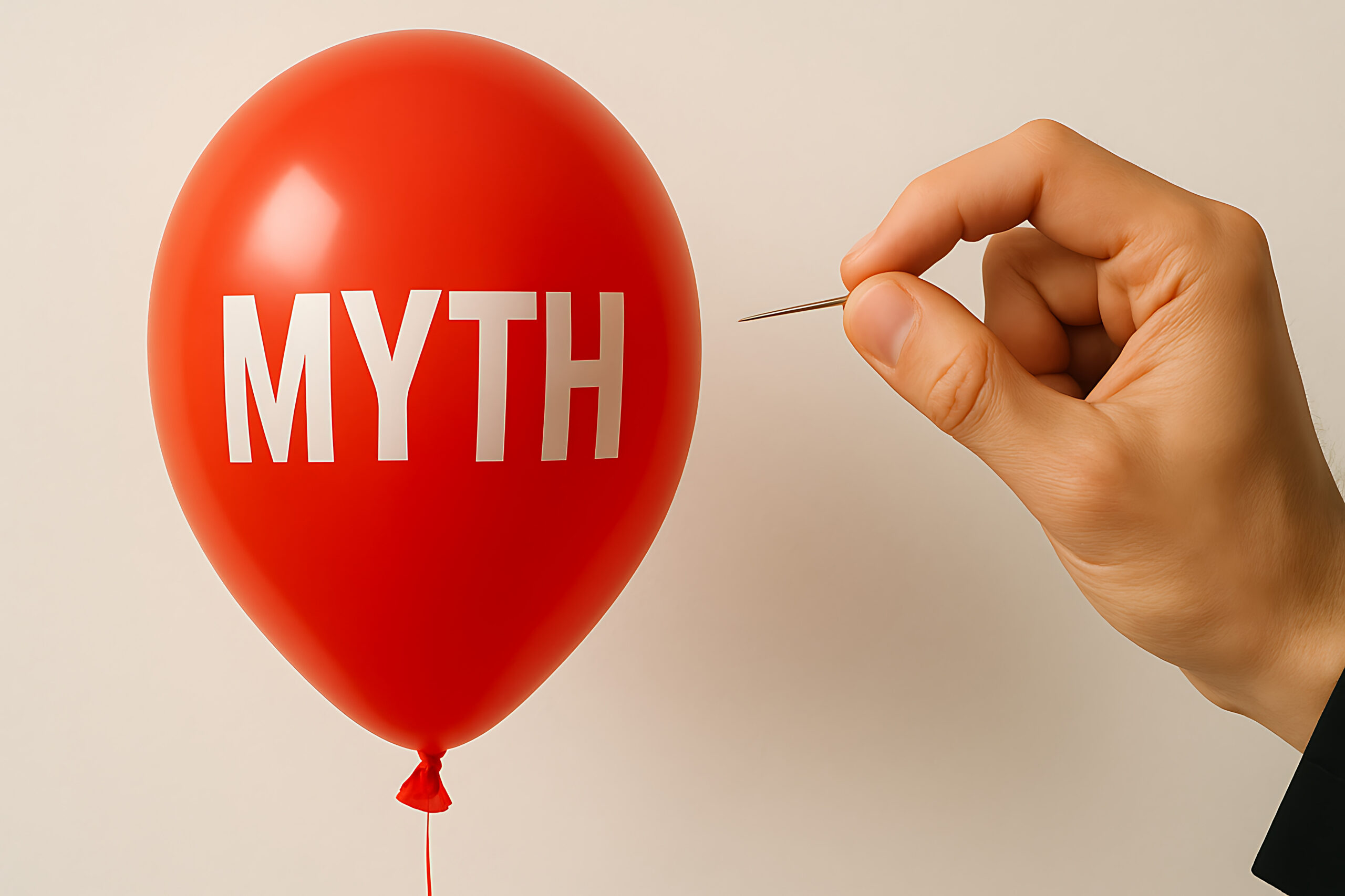 Hand near a pin about to pop a red balloon labeled MYTH, conveying debunking myths intent