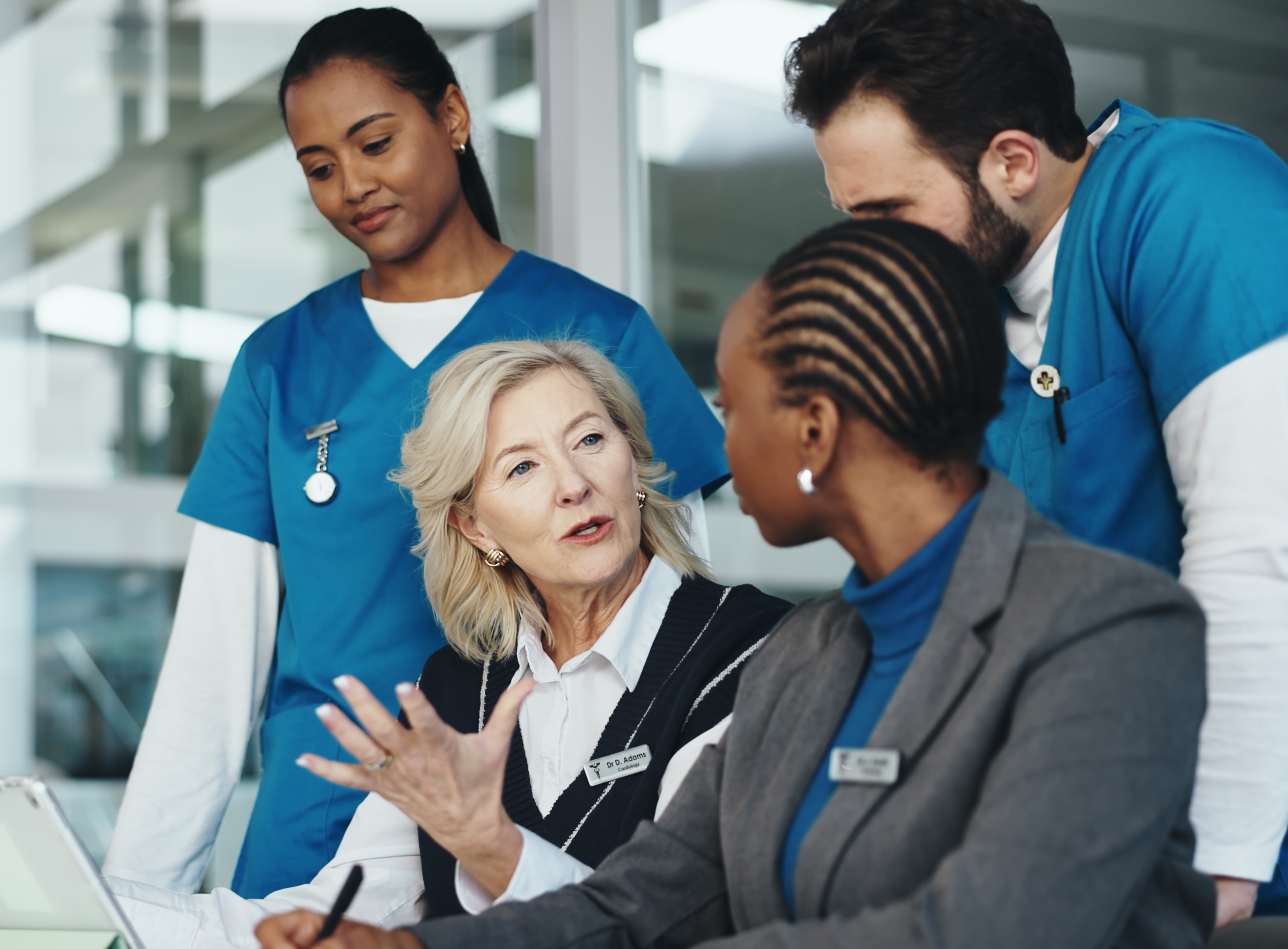 Medical team reviews an elderly patient's chart during a check-up in a clinic hallway.